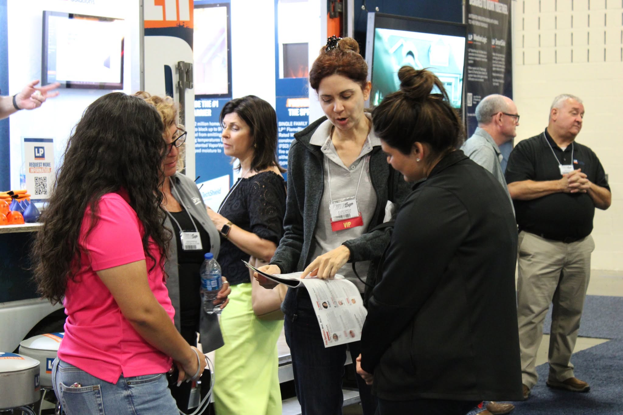 Consultants and business professionals reviewing printed materials at an industry expo, the kind of first impression a consulting portfolio has to make online
